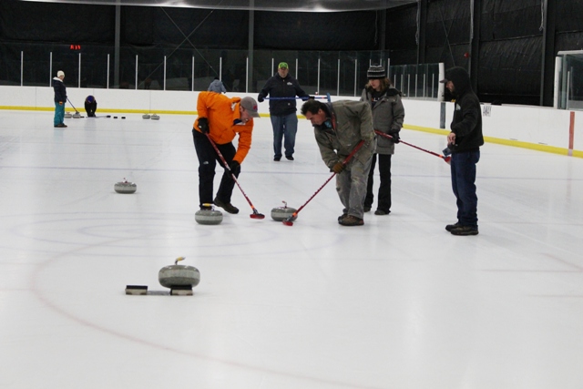 Group of people on ice rink in curling league