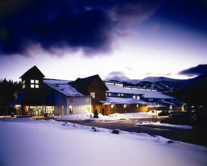 Winter evening exterior of Stephen C. West Ice Arena under dark clouds