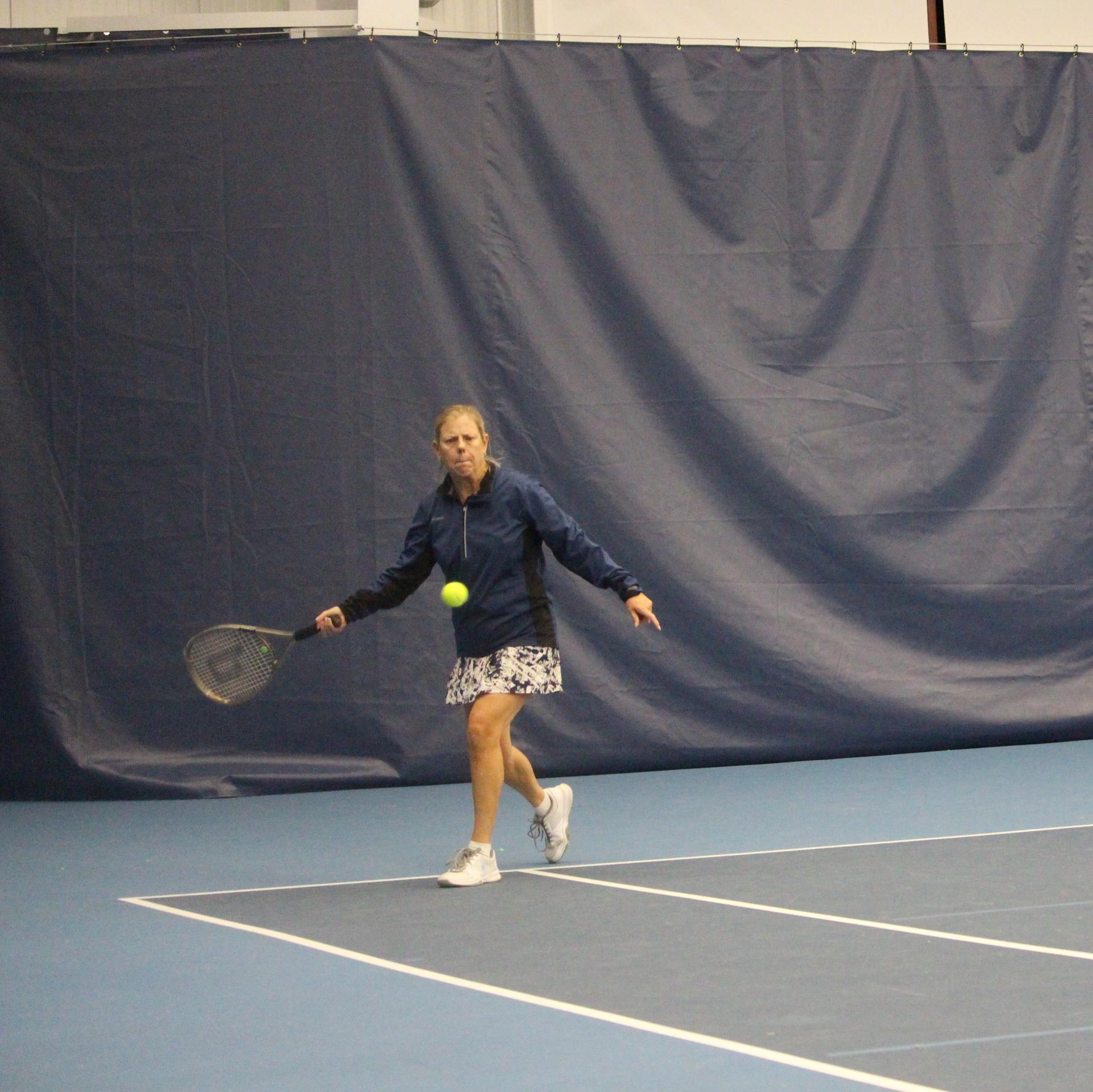 woman playing tennis on indoor court