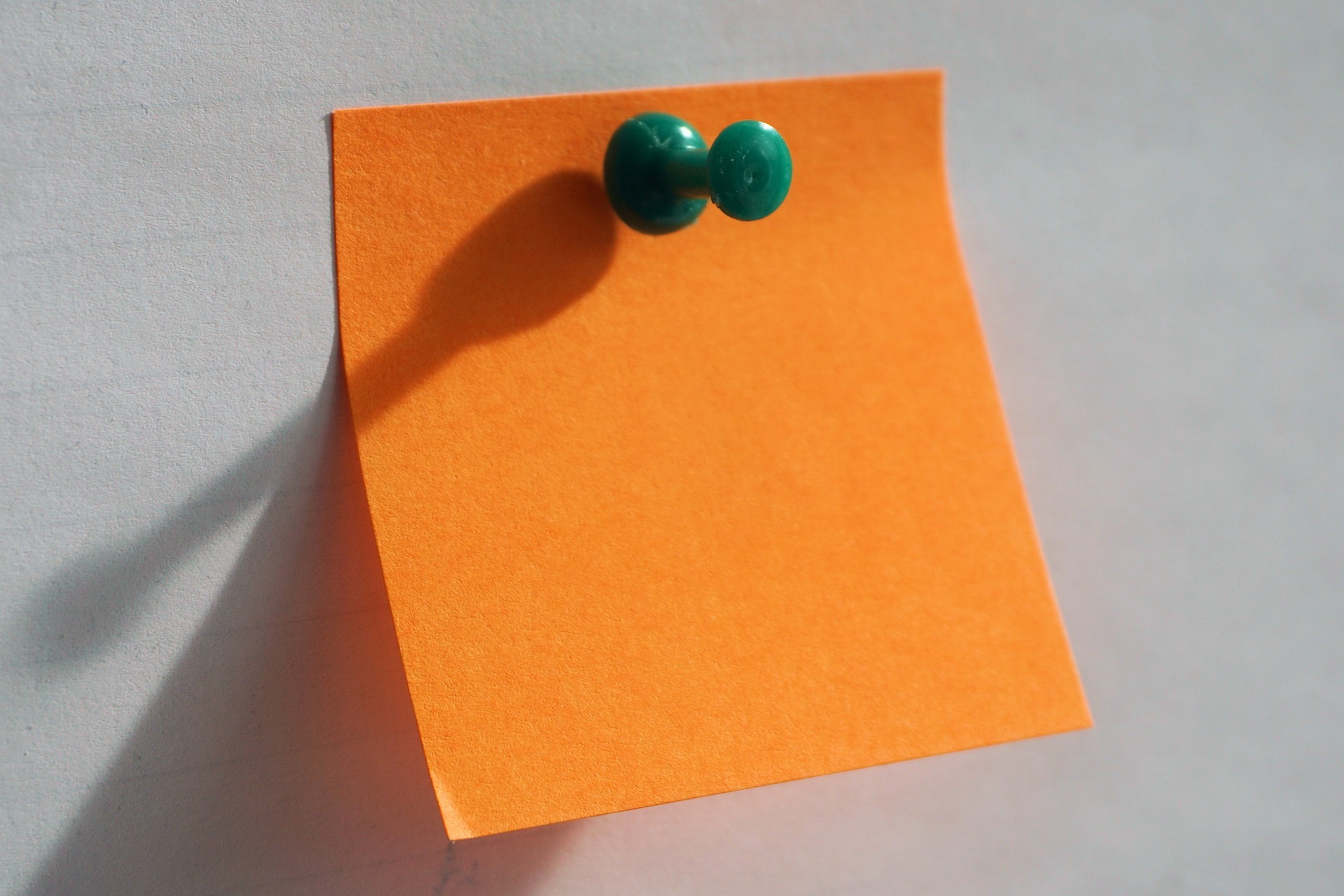 Orange paper with green push pin